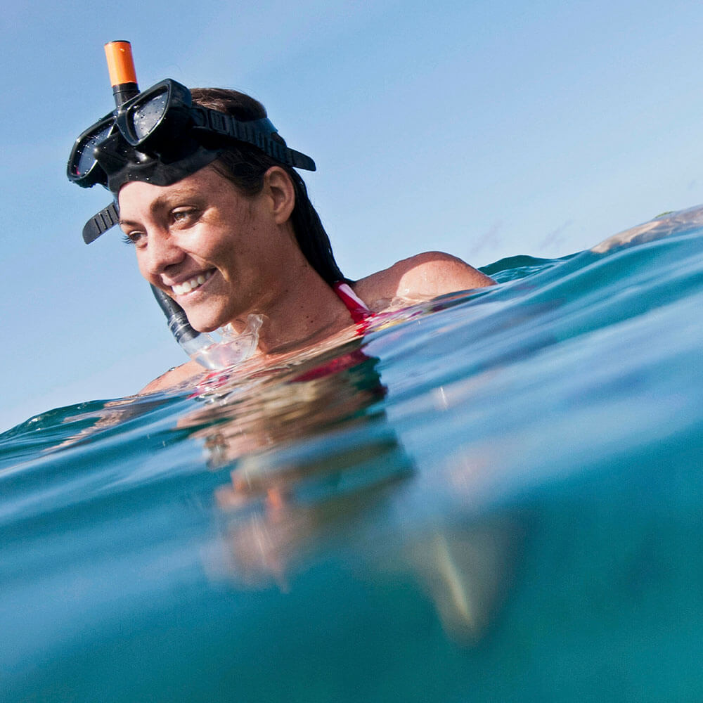 Woman snorkeling in ocean wearing SolRX water resistant sunscreen clear water