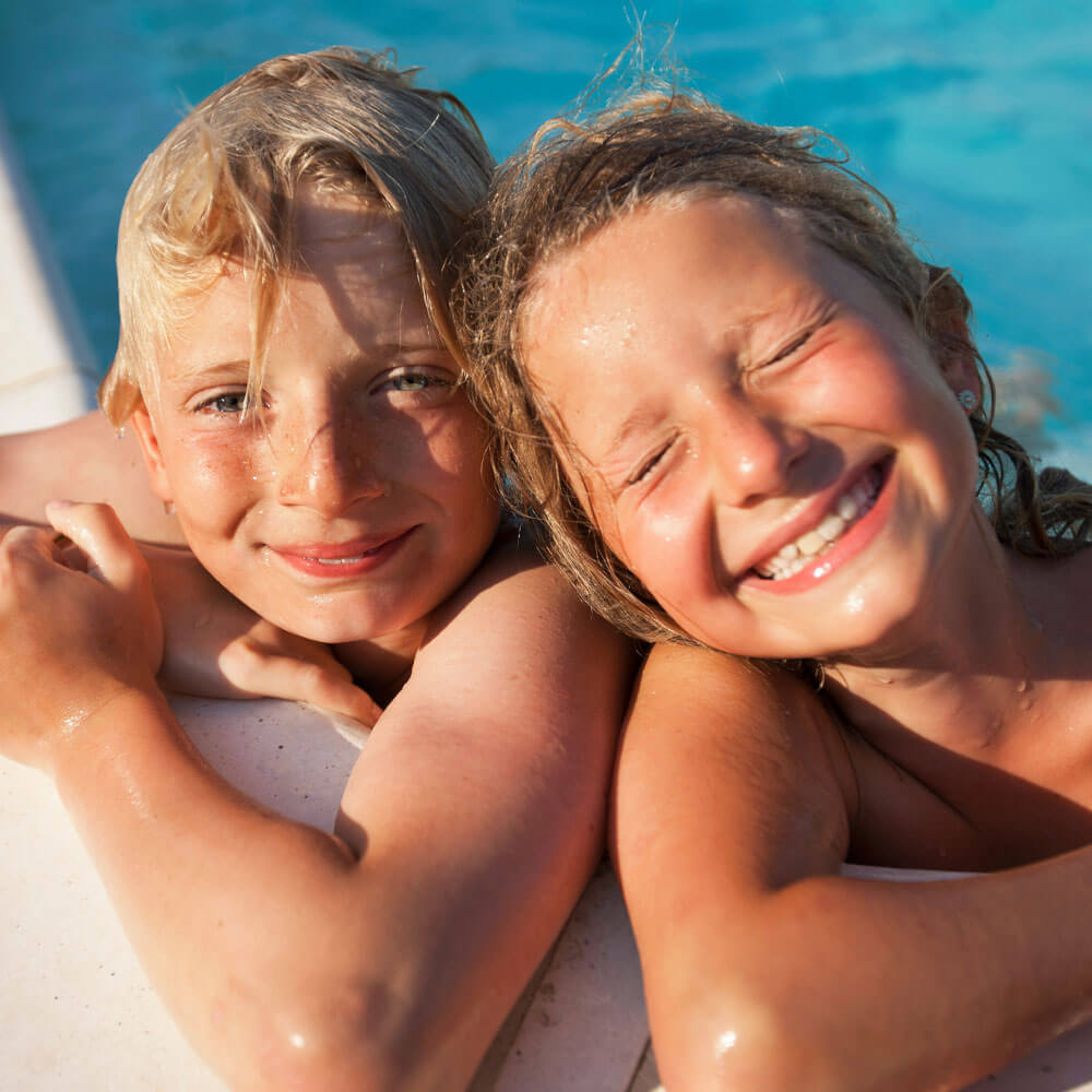 Two children smiling at pool SolRX kids sunscreen tear-free hypoallergenic SPF 50